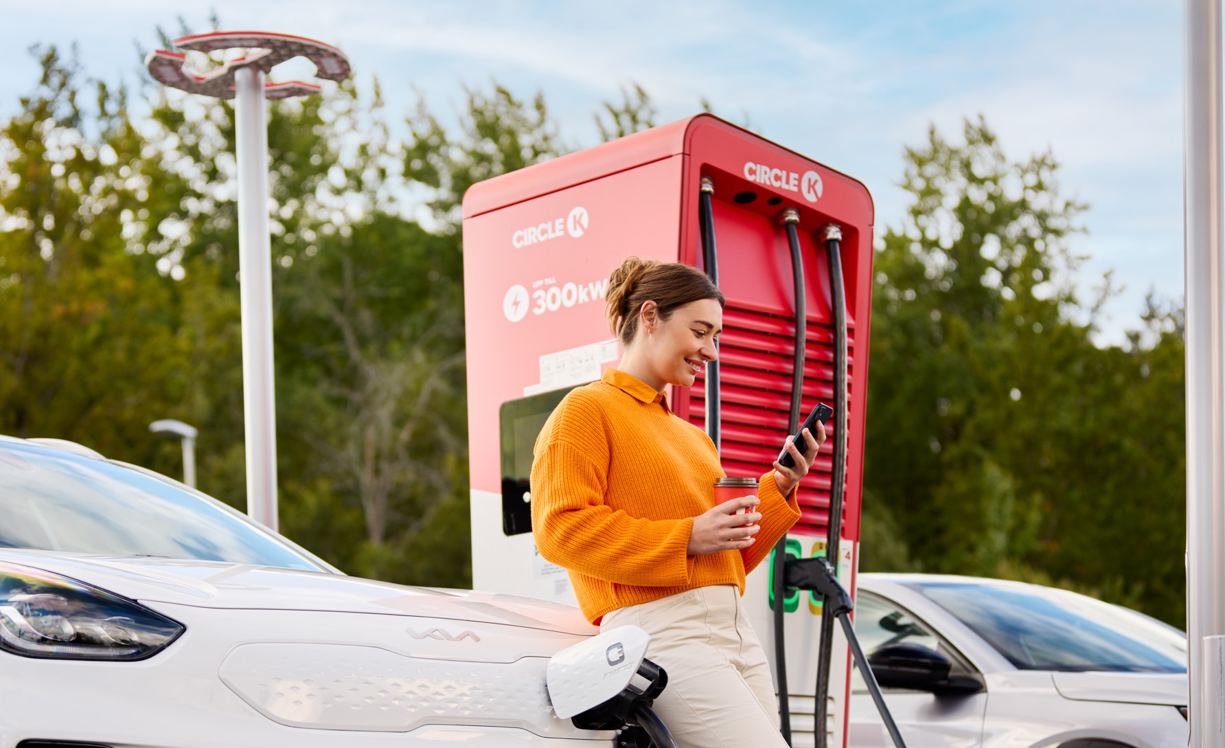 Kvinne lader på en Circle K-stasjon ved hjelp av Autocharge