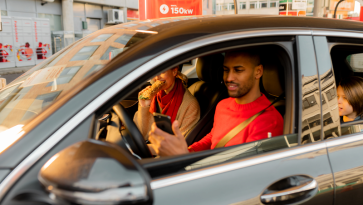Man and woman in car with child at car charging station